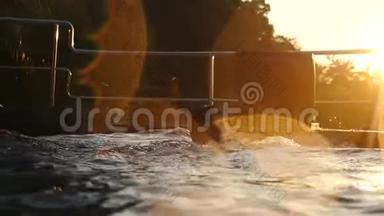 年轻人在热带度假胜地美丽的夕阳下在游泳池里游泳。 假期概念。 慢动作。 1920x1080